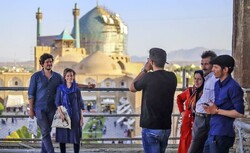 A foreign couple (L) poses for a photo during a visit to the UNESCO-tagged Imam Square, Isfahan, central Iran.