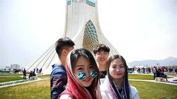 File photo shows Chinese citizens in Tehran with Borj-e Azadi “Azadi Tower” in the background