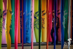 A man walks past flags bearing logos for the Fajr Film Festival at Tehran’s Mellat Cineplex, February 2019. (FFF/Bahar Asgari) 