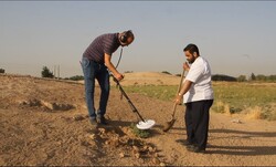 A stock photo depicts people using a metal detector