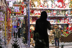 Festive lights and Santa Claus figures decorate window displays of some shops in Tehran as shoppers visit streets to purchase Christmas presents on a mild and overcast night, December 28, 2019.