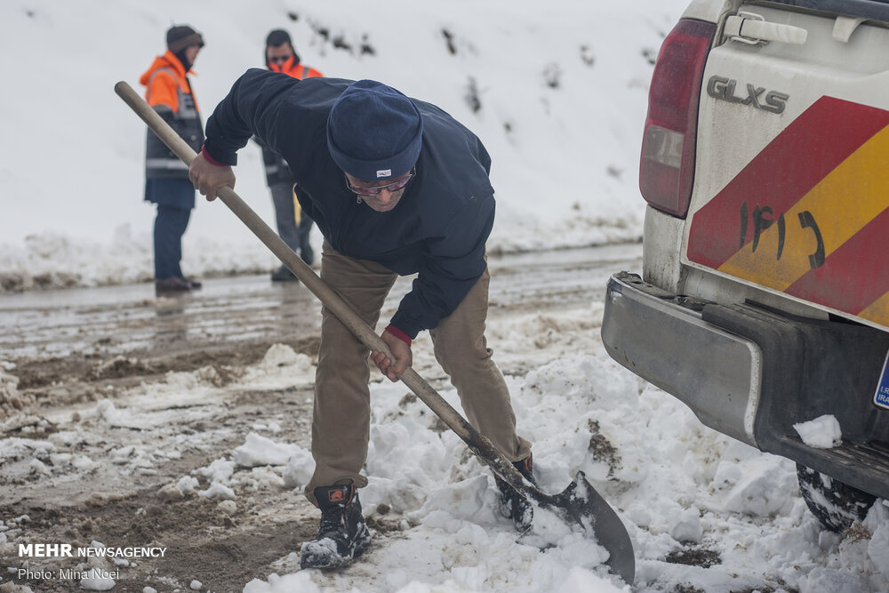 رجالٌ مهمتهم إزالة الثلج عن طرقٍ أغلقتها الثلوج