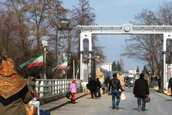  People walk toward an Iran-Azerbaijan border crossing gate