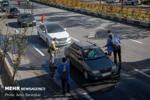 Students disinfect passing cars against COVID-19 in Shiraz