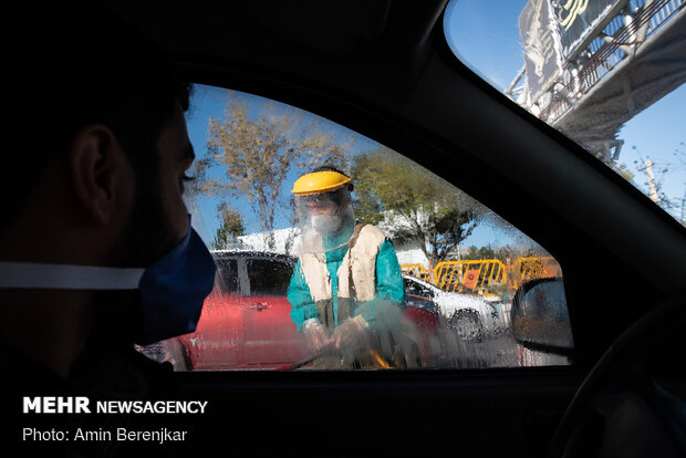 Students disinfect passing cars against COVID-19 in Shiraz