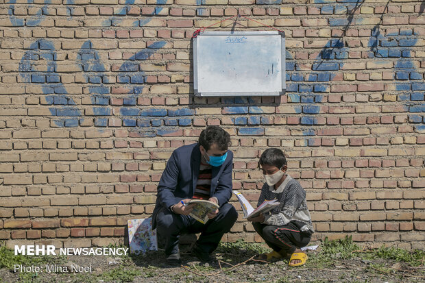 اقای سهرابی و شاگردانش  این روزها برای حفظ سلامتی  با استفاده از ماسک و در فضایی باز درس می خوانند  