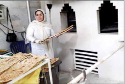 زنی که همپای شوهرش پای تنور نانوایی کار می‌کند