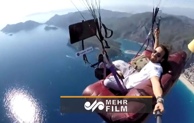 VIDEO: A paraglider flies off cliff while sitting on sofa