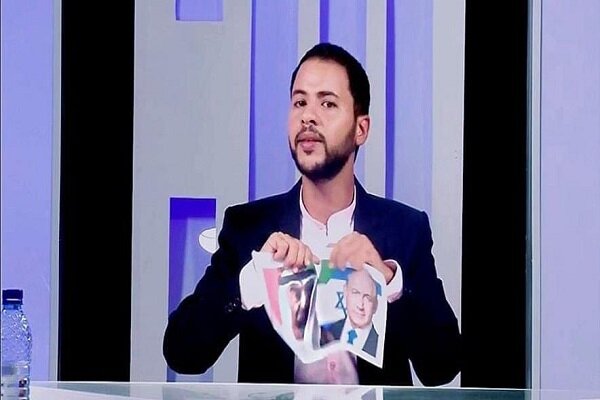 إعلامي تونسي يمزق صور ولي عهد أبو ظبي ورئيس وزراء حكومة الاحتلال الصهيوني على الهواء