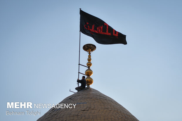 Imam Hussein flag raised up above Shah Abdol-Azim Shrine