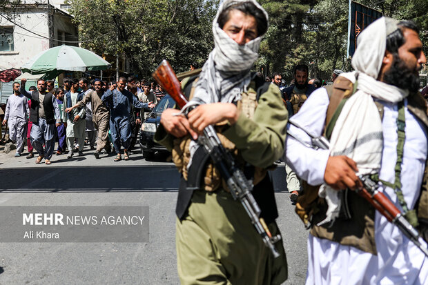دو نفر از اعضاء طالبان در جلو معترضان به دخالت پاكستان در افغانستان و بمباران دره پنجشير در خيابان هاى كابل