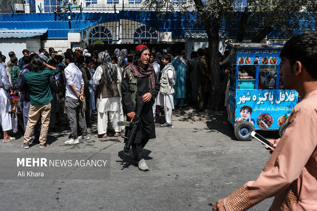 يكى از نيروهاى طالبان در حال گشت زنى مقابل بانكى در كابل. اين روزها تجمعات زيادى مقابل بانك ها براى بازپس گرفتن پول هاى خود شكل ميگيرد.