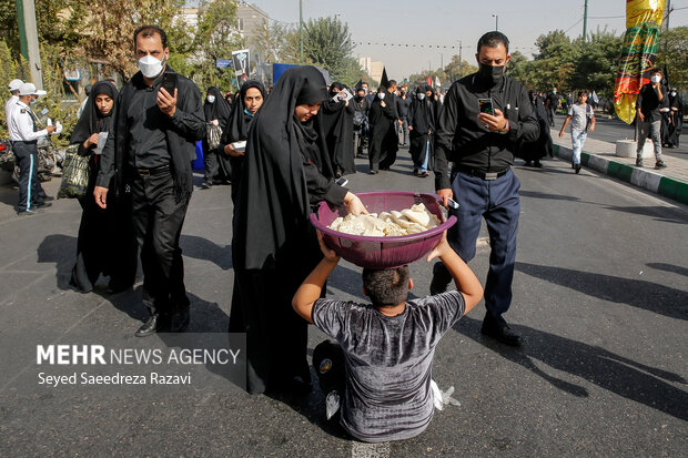 نوجوانی با پخش نذری در مراسم راهپیمایی جاماندگان اربعین حسینی(ع) شرکت کرده است