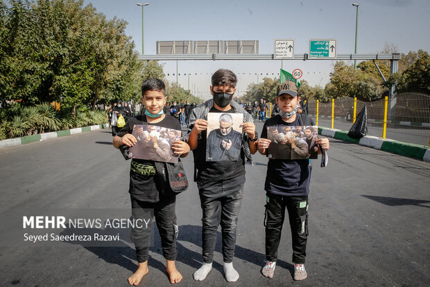 سه نوجوان با پای برهنه و عکس سردار شهید؛ حاج قاسم سلیمانی در مراسم راهپیمایی جاماندگان اربعین حسینی(ع) حضور دارند