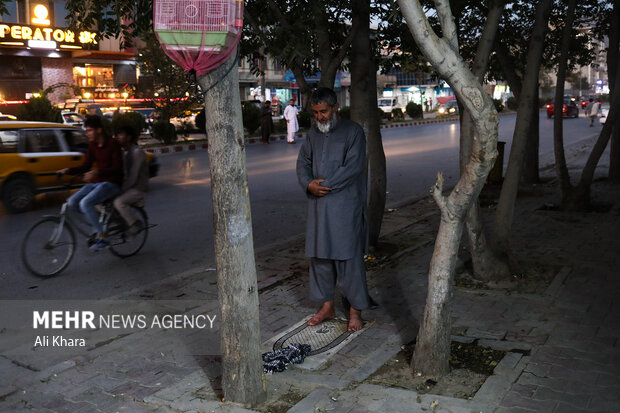 يك مرد افغان در حال خواندن نماز در يكى از خيابان هاى كابل است