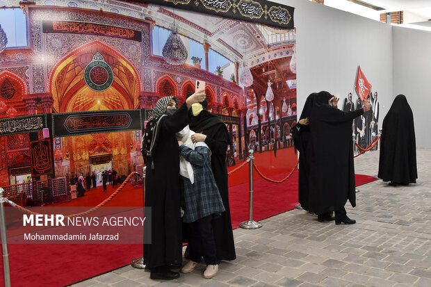 بازدیدکنندگان در حال گرفتن عکس یادگاری با نمای پانورامای حرم اباعبدالله الحسین (ع) هستند