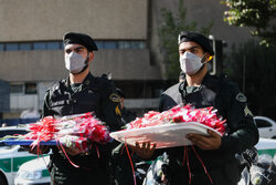 تقديم قوات الأمن الداخلي الإيراني الزهور للمواطنين المارّة/بالصور