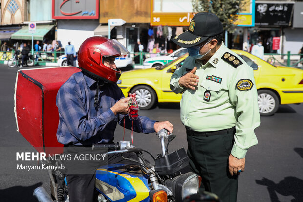 ماموران نیروی انتظامی به مناسبت هفته نیروی انتظامی  به شهروندان تهرانی در میدان ولیعصر گل اهدا کردند 