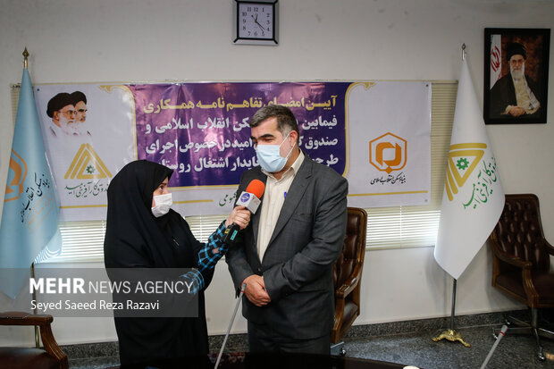 اکبر نیکزاد به عنوان رئیس بنیاد مسکن انقلاب اسلامی درحال پاسخ دادن به سوالات خبرنگاران است