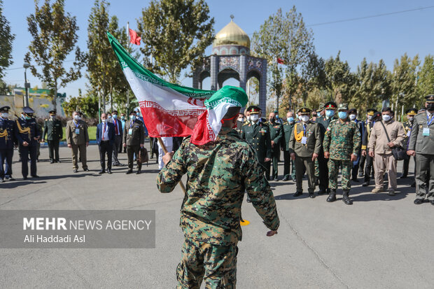 یکی از سربازان نیروی انتظامی در حال خوش آمد گویی به میهمانان مراسم صبحگاه یگان ویژه ناجا است