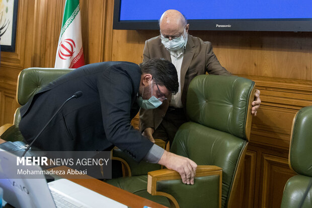 مهدی چمران رئیس شورای شهر تهران در حال تنظیم صندلی خود در جلسه شورای شهر تهران است