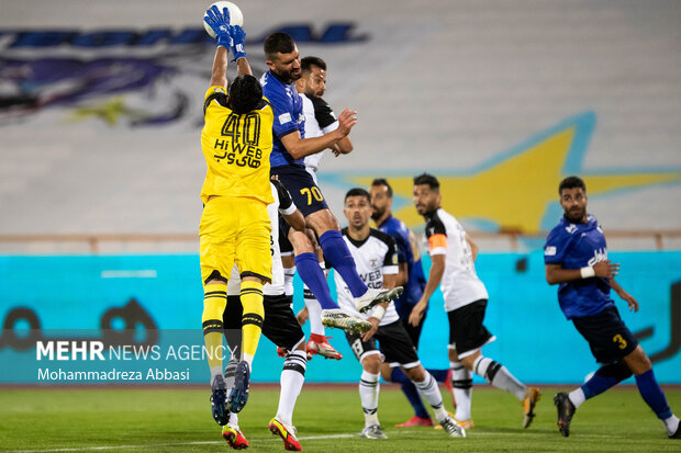 بازیکنان دو تیم در محوطه جریمه تیم فوتبال هوادار تهران  در حال در گیری هستند