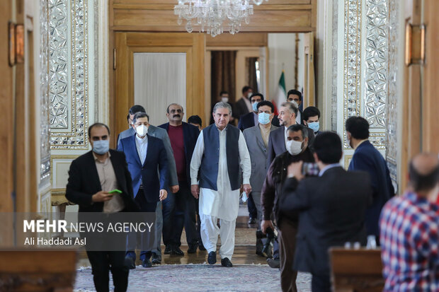 حسین امیر عبدالهیان وزیر امور خارجه ایران و شاه محمود قریشی وزیر امور خارجه پاکستان در حال آمدن به سالن نشست خبری هستند