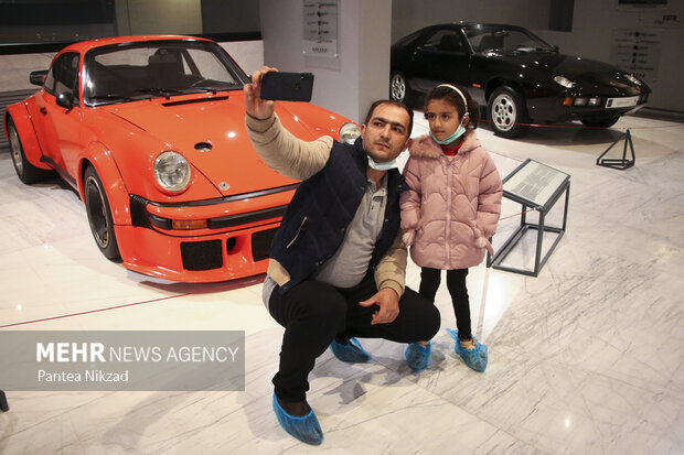 بازدیدکنندگان از موزه خودروهای تاریخی ایران در حال گرفتن عکس یادگاری در کنار خودروها هستند