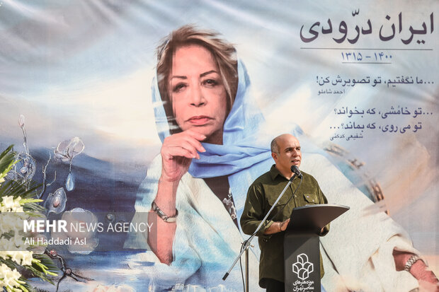 پیام دهکردی بازیگر سینما تئاتر و تلویزیون در حال سخنرانی در مراسم تشییع پیکر مرحومه ایران درودی هنرمند نقاش است