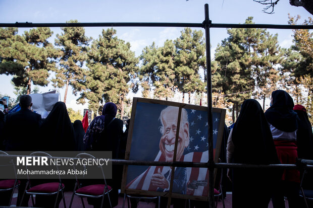 تصویر کاریکاتور جو بایدن در مراسم یوم الله ۱۳ آبان در تهران در مقابل لانه جاسوسی آمریکا در تصویر دیده می شود