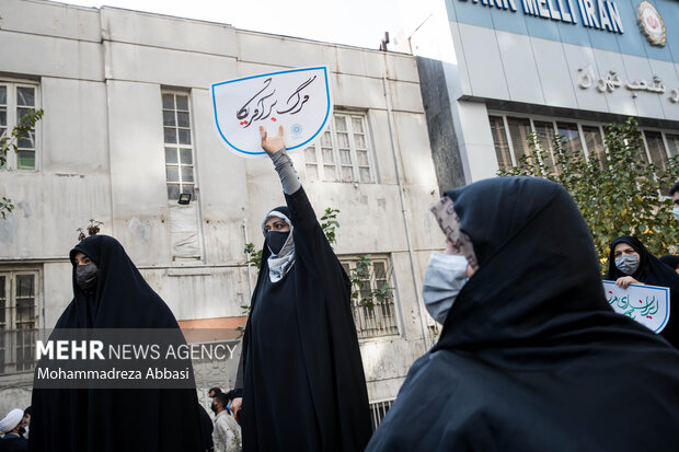 یکی از حاضرین در مراسم یوم الله ۱۳ آبان در تهران شعار مرگ بر آمریکا در دست دارد