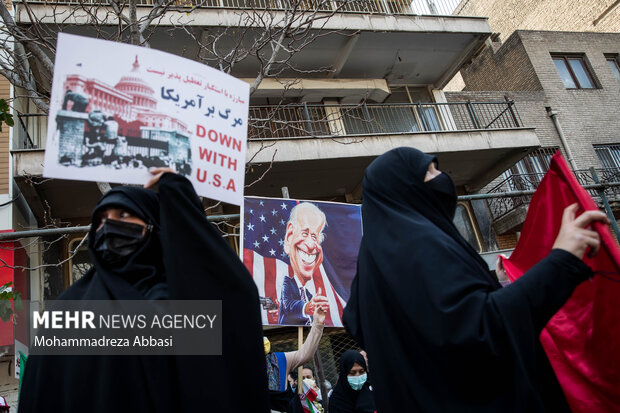 تصویر کاریکاتور جو بایدن در مراسم یوم الله ۱۳ آبان در تهران در مقابل لانه جاسوسی آمریکا در تصویر دیده می شود