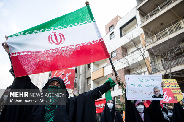 یکی از دانش آموزان حاضر در مراسم یوم الله ۱۳ آبان در تهران پرچم مقدس جمهوری اسلامی ایران را در دست دارد