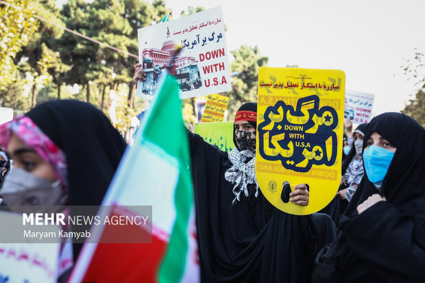 پلاکارد مرگ بر آمریکا در دست شرکت کنندگان در راهپیمایی 13 آبان در تهران می باشد