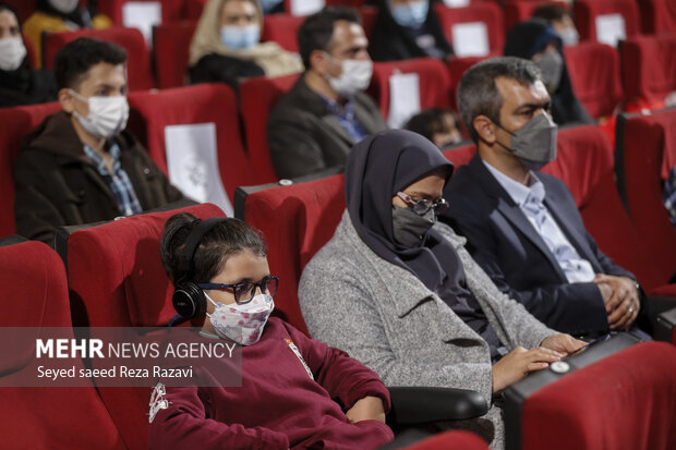 یک کودک خردسال به همراه خانواده خود در مراسم اختتامیه هفتمین جشنواره فیلم کوتاه دانش آموزی حضور دارد