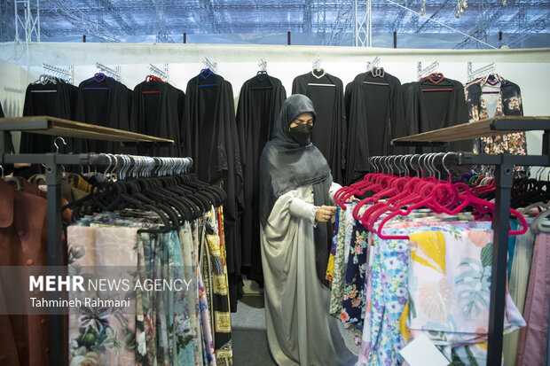 یکی از بازدید کنندگان در حال بازدید از محصولات ارائه شده در نمایشگاه عفاف و حجاب است