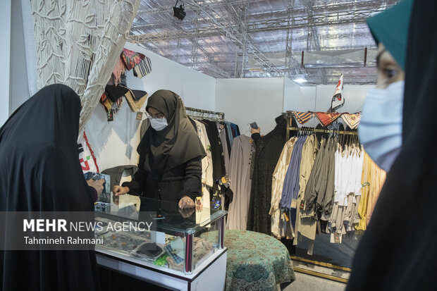 یکی از بازدید کنندگان در حال بازدید از محصولات ارائه شده در نمایشگاه عفاف و حجاب است