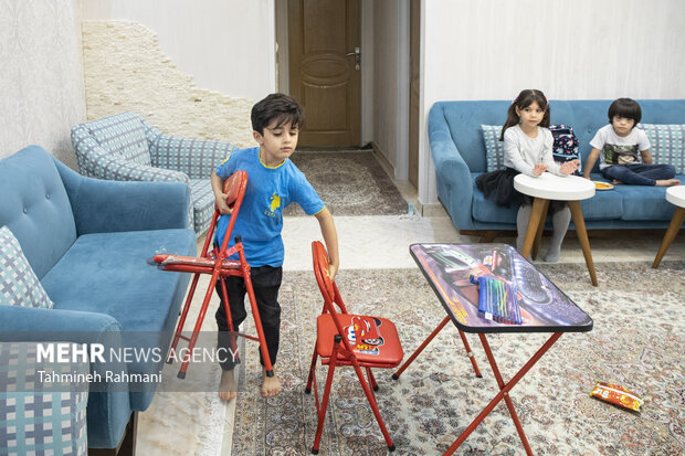 ارمیا، که یکی از کودکان تازه وارد پیش دبستانی ست، در حال جمع آوری میز و صندلی های کلاس درس است تا فضا برای زنگ بعد آماده شود