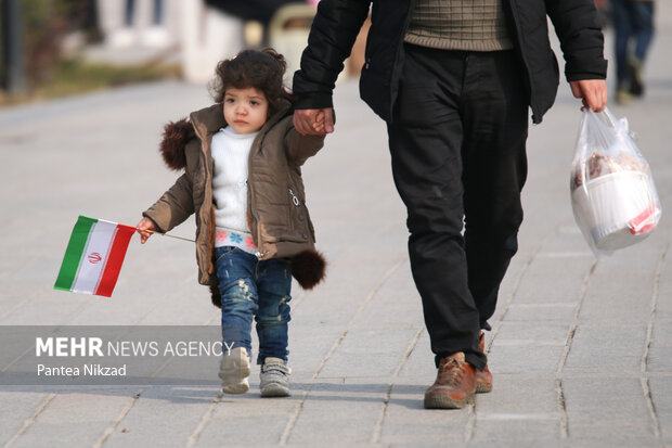 پدری به همراه فرزند خردسال خود در همایش پیاده روی خانوادگی شرکت کرده است