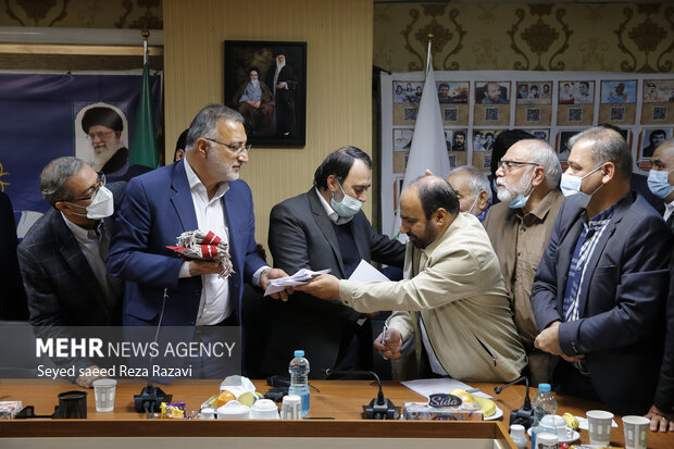 علیرضا زاکانی شهردار تهران در حال گرفتن نامه از یکی از نخبگان پس از پایان دیدار شهردار تهران  با نخبگان منطقه ۱۶  است