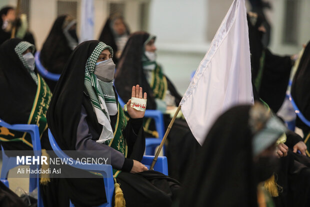 یک بسیجی حاضر در تجمع بزرگ ۵ هزار نفری بسیجیان تهران بزرگ سربند لبیک یا خامنه ای را در دست گرفته و در حال شعار دادن است