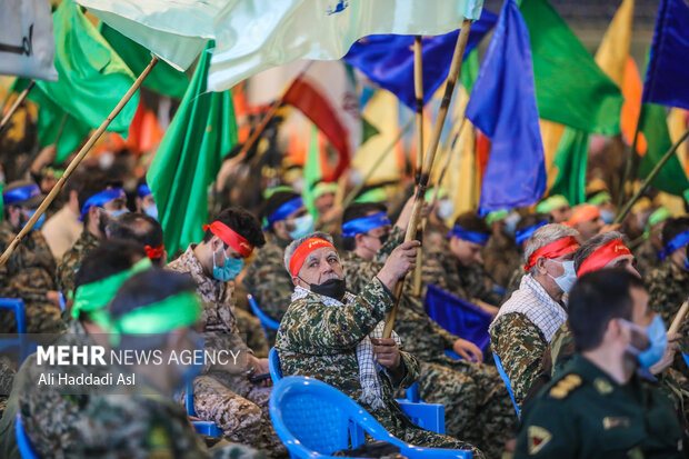 بسیجیان حاضر در تجمع بزرگ ۵ هزار نفری بسیجیان تهران بزرگ با تکان دادن پرچم های خود شعار می دهند