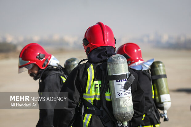 شرکت کنندگان بخش هدف زنی با آب در مسابقات ورزشی آتش نشانان نیروی هوای ارتش آماده شروع مسابقه هستند