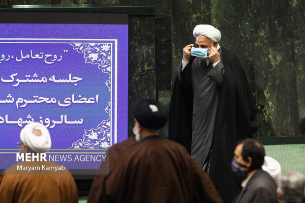 حجت الاسلام غلامحسین محسنی اژه ای رئیس قوه قضائیه در حال زدن ماسک پس از اتمام سخنرانی در نشست مشترک مجلس و قوه قضاییه است