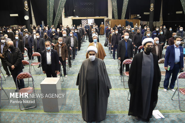 حاضرین در مراسم بزرگداشت سردار سلیمانی در حال ادای احترام به سرود جمهوری اسلامی ایران هستند