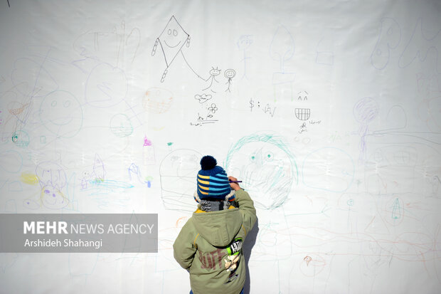 کودکی در حال نقاشی در جشنواره بادبادک باز هستند