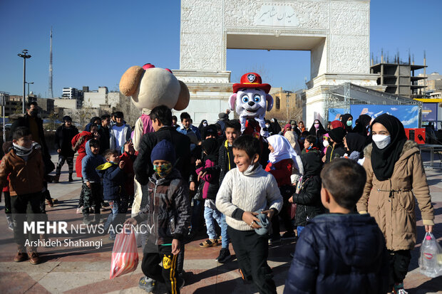 کودکان و خانواده هایشان در حال ورود به محل جشنواره بادبادک باز هستند 
