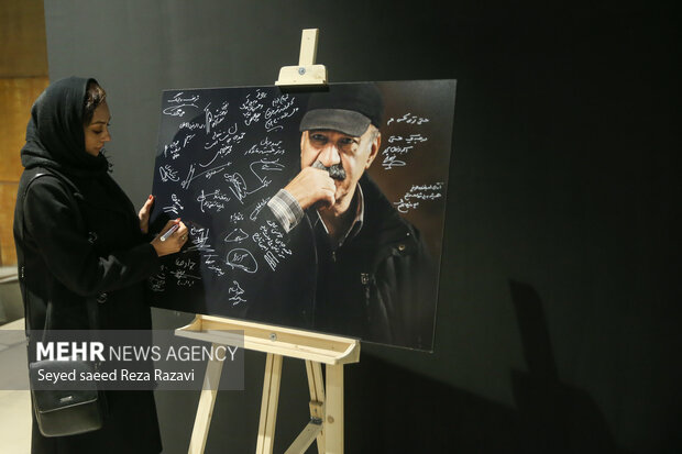  یکتا ناصر بازیگر در حال نوشتن بر پوستر یادبود حمید لبخنده است