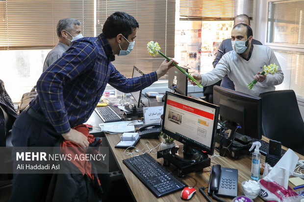 محمد شجاعیان مدیرعامل گروه رسانه ای مهر در حال تقدیم گل به خبرنگاران مهر به مناسبت میلاد با سعادت حضرت فاطمه (س) است