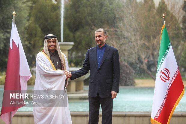 حسین امیر عبدالهیان وزیر امور خارجه کشورمان و محمد بن عبدالرحمن آل ثانی، معاون نخست وزیر و وزیر امور خارجه قطر در حال دست دادن و گرفتن عکس یادگاری هستند